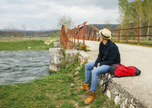 Solo traveler sitting by a scenic river for local tours